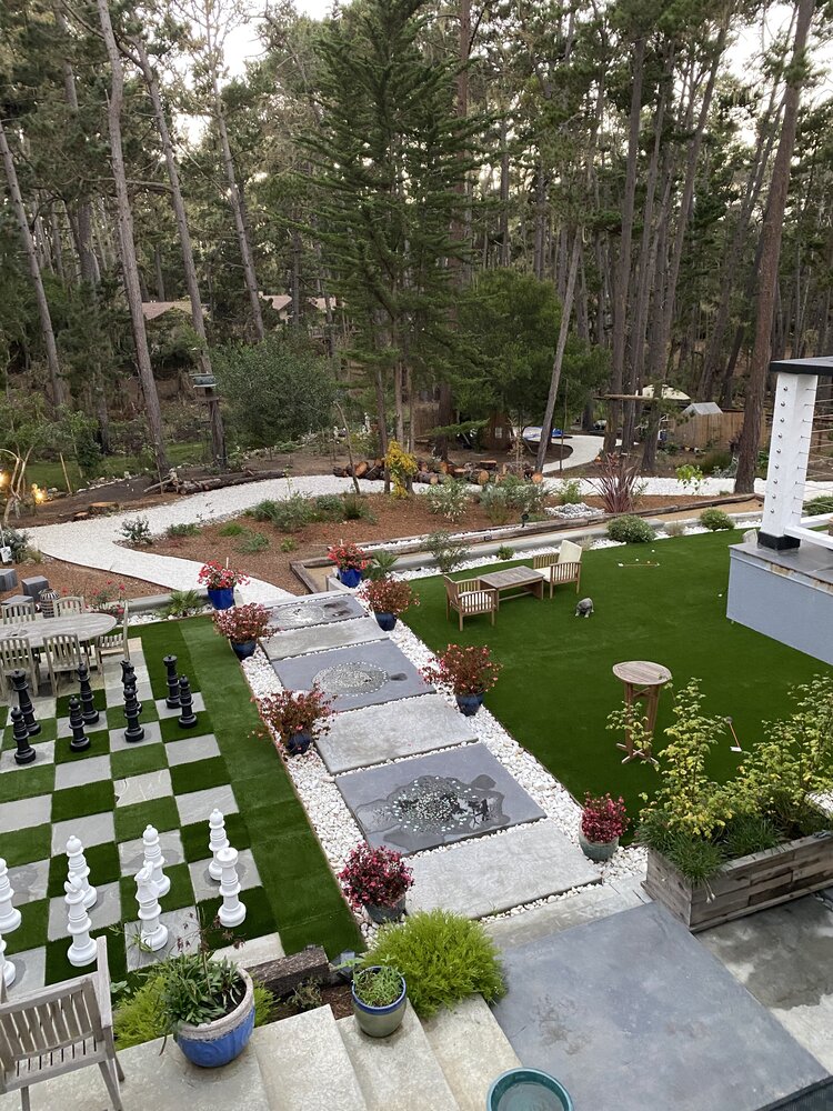 A backyard with a chess set on a lawn.