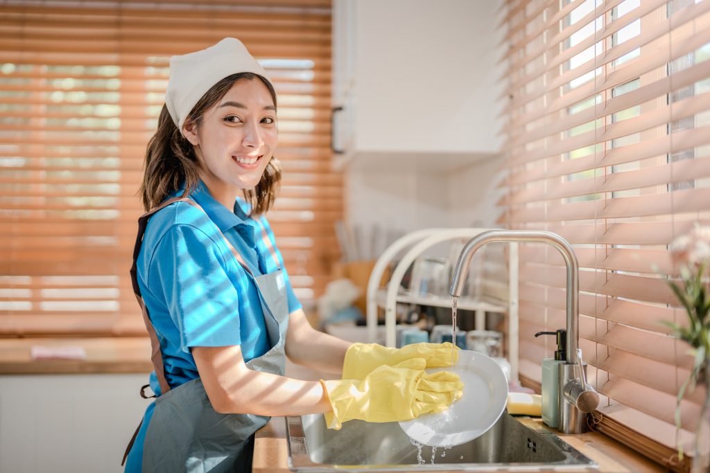 A friendly household helper in a kitchen, representing reliable staffing solutions